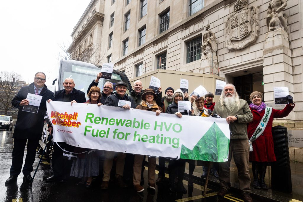 Beboere fra Kehelland i Cornwall leverer høringssvaret sitt til det britiske energidepartementet i Whitehall, bak en banner med teksten Renewable HVO Fuel for heating
